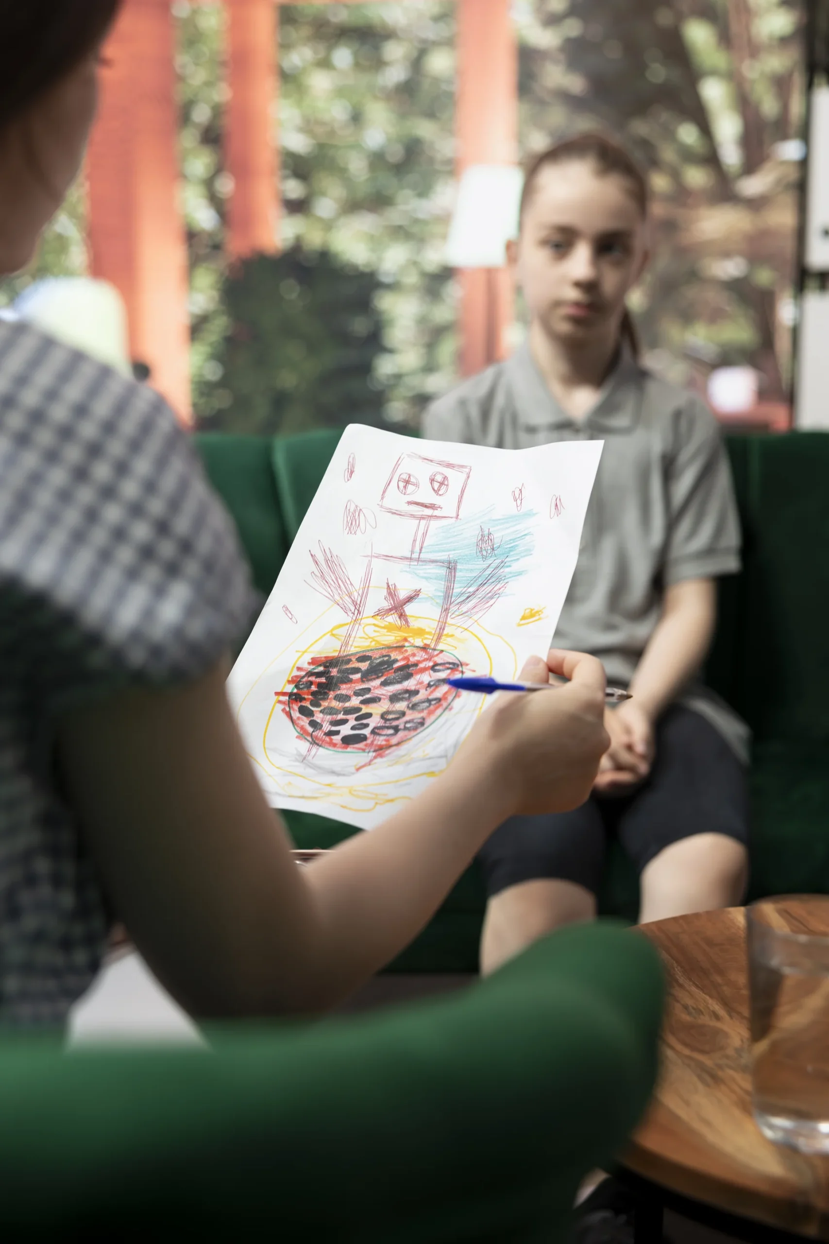 Psicoterapia adolescenti a Torino: ragazzo che mostra un disegno alla psicologa