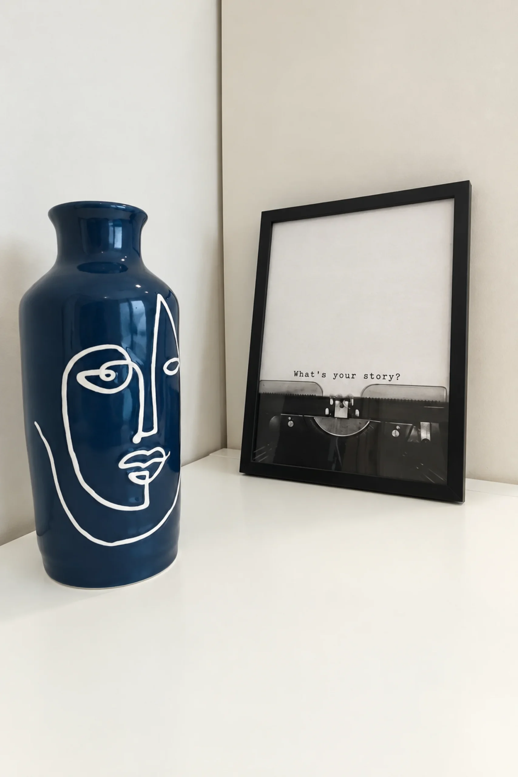 Vaso blu dipinto con un volto accanto a una cornice nello studio